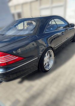Schräge Heckansicht des polierten dunkelgrünen Mercedes CL: Die polierte Oberfläche reflektiert perfekt das Licht, während die charakteristischen Linien und Rückleuchten des Fahrzeugs hervorgehoben werden.