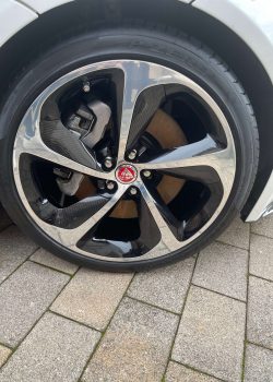 Seitenansicht des weißen Jaguars mit offener Fahrertür, einladend den Blick auf den eleganten Innenraum freigebend.