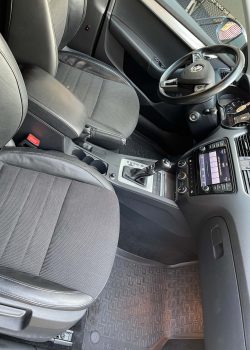 Innenansicht des Skoda Octavia 3, aufgenommen von der Beifahrertür aus: zeigt beide Vordersitze, das Lenkrad und die Frontkonsole in detaillierter Klarheit, hervorhebend die qualitativen Details und die durchdachte Gestaltung des Fahrzeuginnenraums.