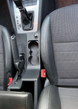 Nahaufnahme des Innenraums des Skoda Octavia: Detailansicht des Getränkehalters, des Schaltknaufs und des Handbremshebels, hervorhebend die qualitative Verarbeitung und das funktionale Design dieser Elemente.